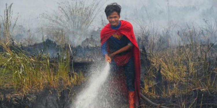Vestito da Superman spegne incendi, il 17enne indonesiano star del web: Il governo lo nomina "eroe"
