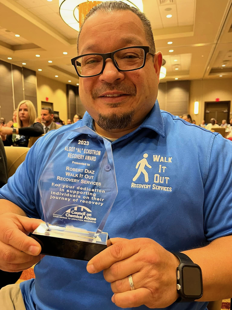 Robert Diaz holding an award.