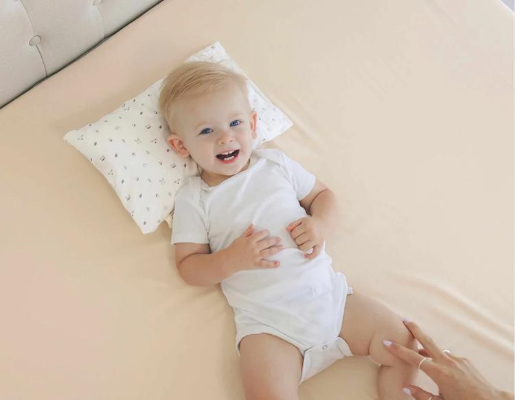 Baby lying awake in bed during bedtime, active and not ready to sleep.