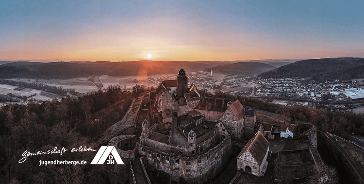  Ansicht der Jugendherberge Burg Breuberg aus der Vogelperspektive zum Sonnenuntergang.