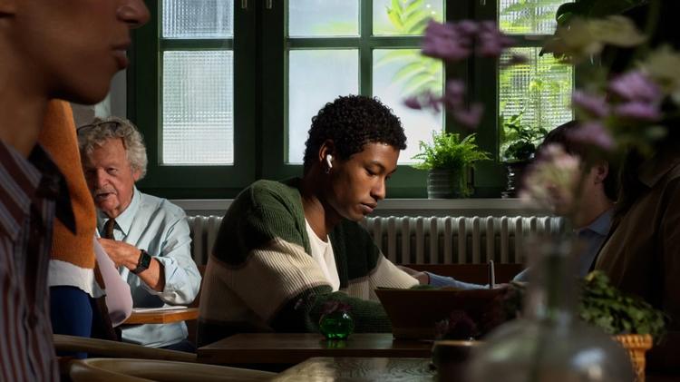 person in cafe wearing airpods 5