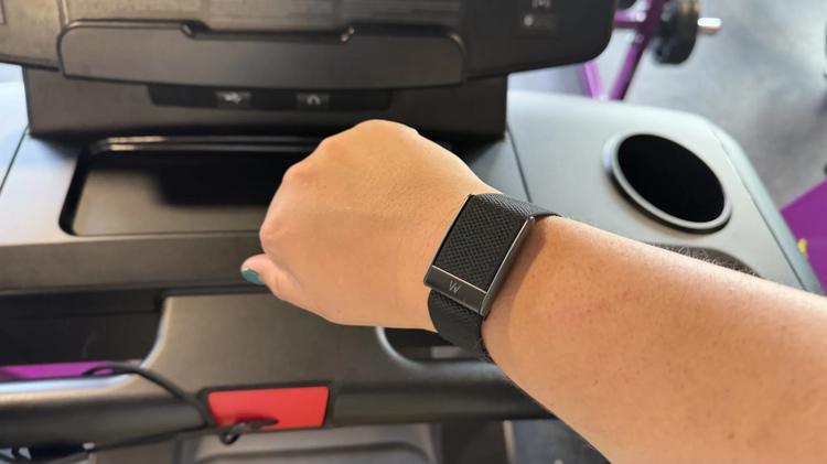 A person wearing a Whoop 5.0 on a treadmill.