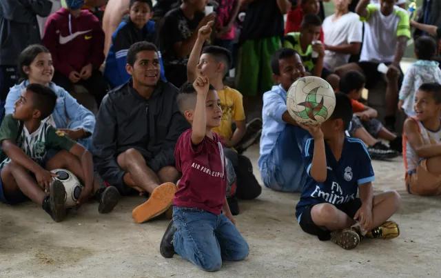 Children in a Bible class holding soccer balls.