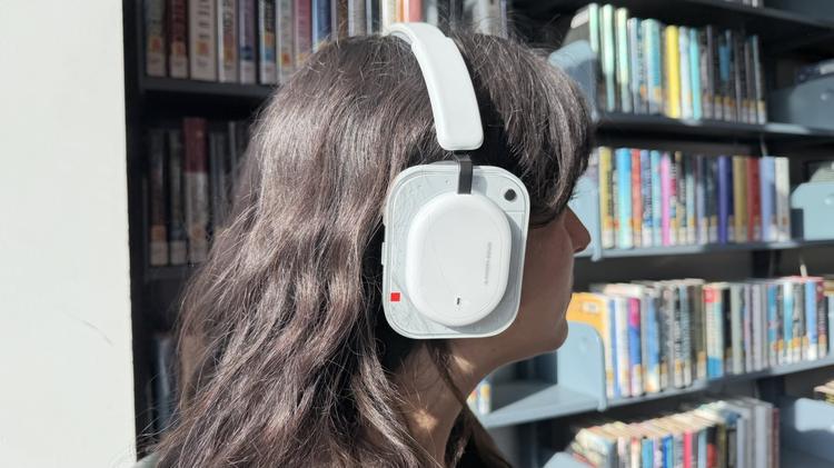 woman wearing nothing headphone (a) in front of bookshelf