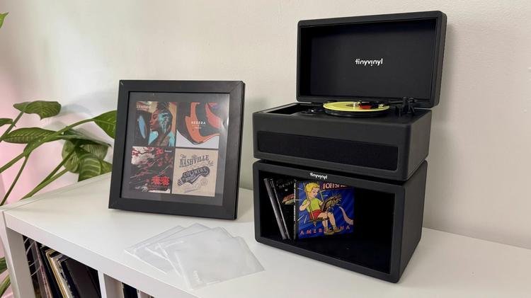 the tiny vinyl player, crate, and display stand on a white media console