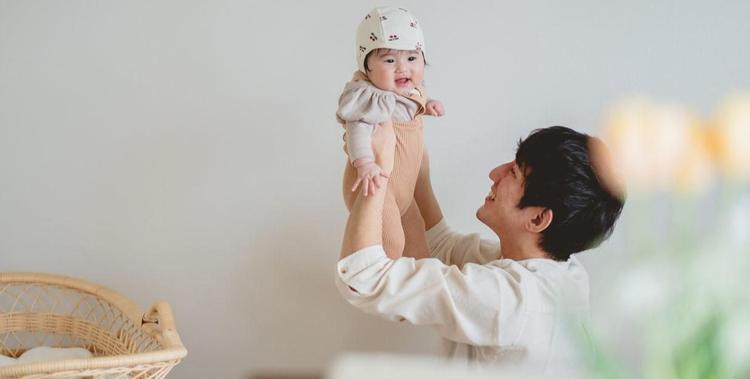  Vater der ein Baby in den Armen hält