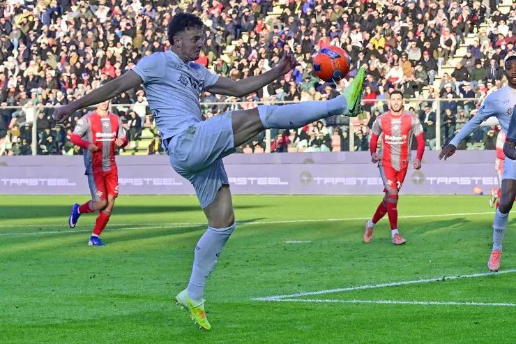 Rrahmani salta per colpire il pallone durante una partita di calcio nello stadio