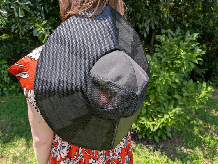 the ecoflow power hat worn on the back of a person who's standing outside
