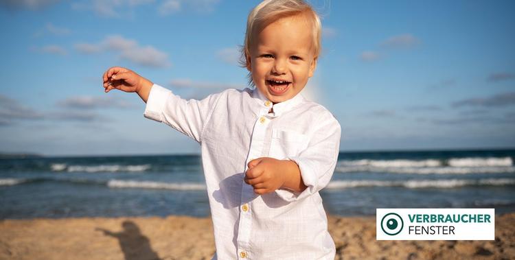  Fröhlicher kleiner Junge der am Strand läuft