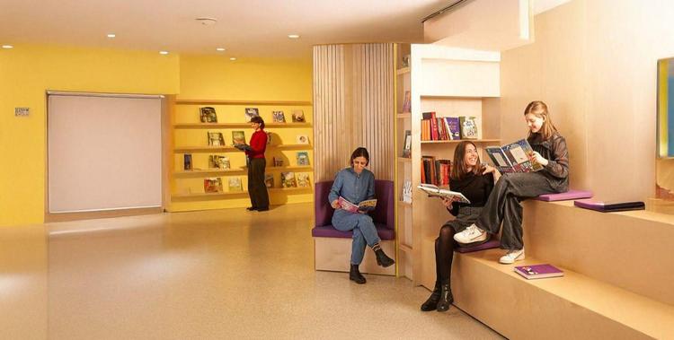  Menschen sitzen in der Leserei unterhalten sich und lesen Bücher