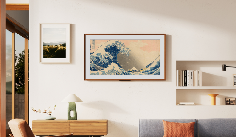 Amazon Ember Artline TV hanging on wall near framed art, a shelf, and a couch