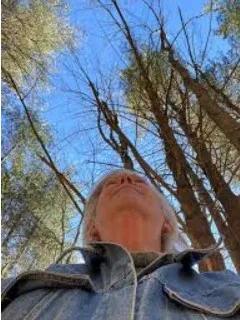 Photo of author Sue Heavenrich looking up into the trees.
