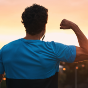 Person flexing arm at sunset