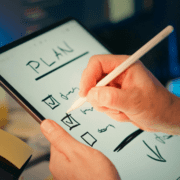 A person uses a stylus to check off items on a digital checklist labeled 