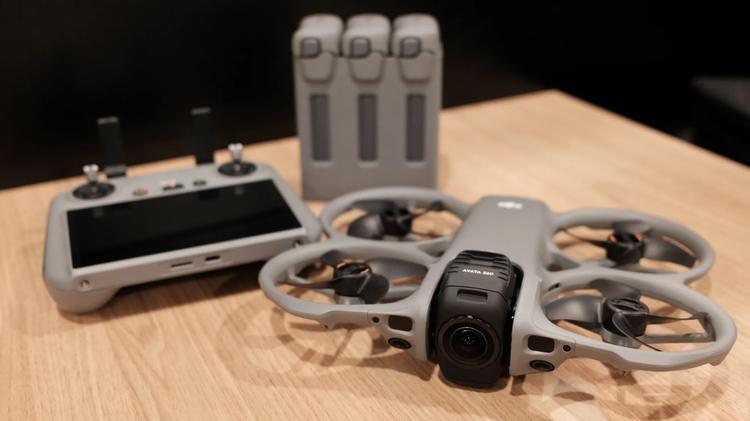 The DJI Avata 360 drone next to a DJI RC 2 remote controller and three batteries in a charging hub.