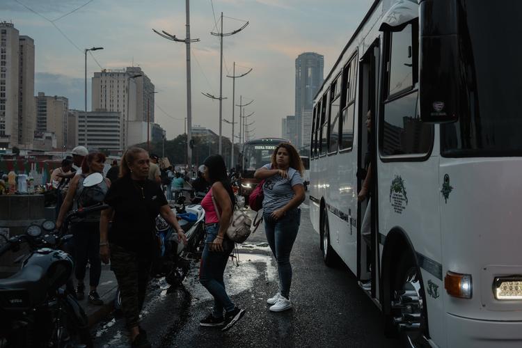Una mujer se baja de un autobús en el centro de Caracas.