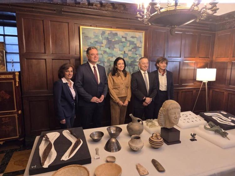 Officials including Matthew Bogdanos, head of the Antiquities Trafficking Unit, and Greek cultural authorities stand in front of 29 ancient Greek artifacts during the handover ceremony at the Greek Consulate General in New York. 