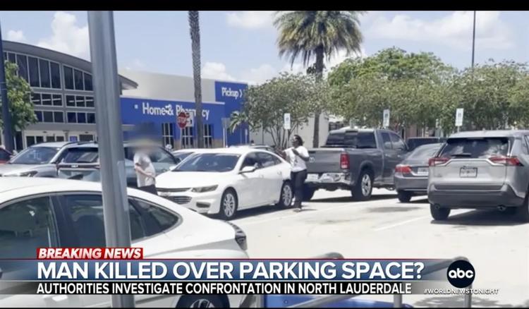 Parking lot with several vehicles, including a white sedan that appears to have been involved in an incident, as indicated by the 