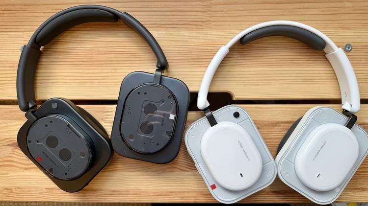 black nothing headphone (1) and white nothing headphone (a) on wooden bench