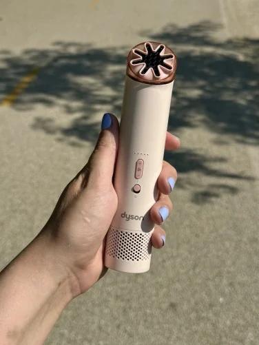 the dyson hushjet mini cool in a woman's hand