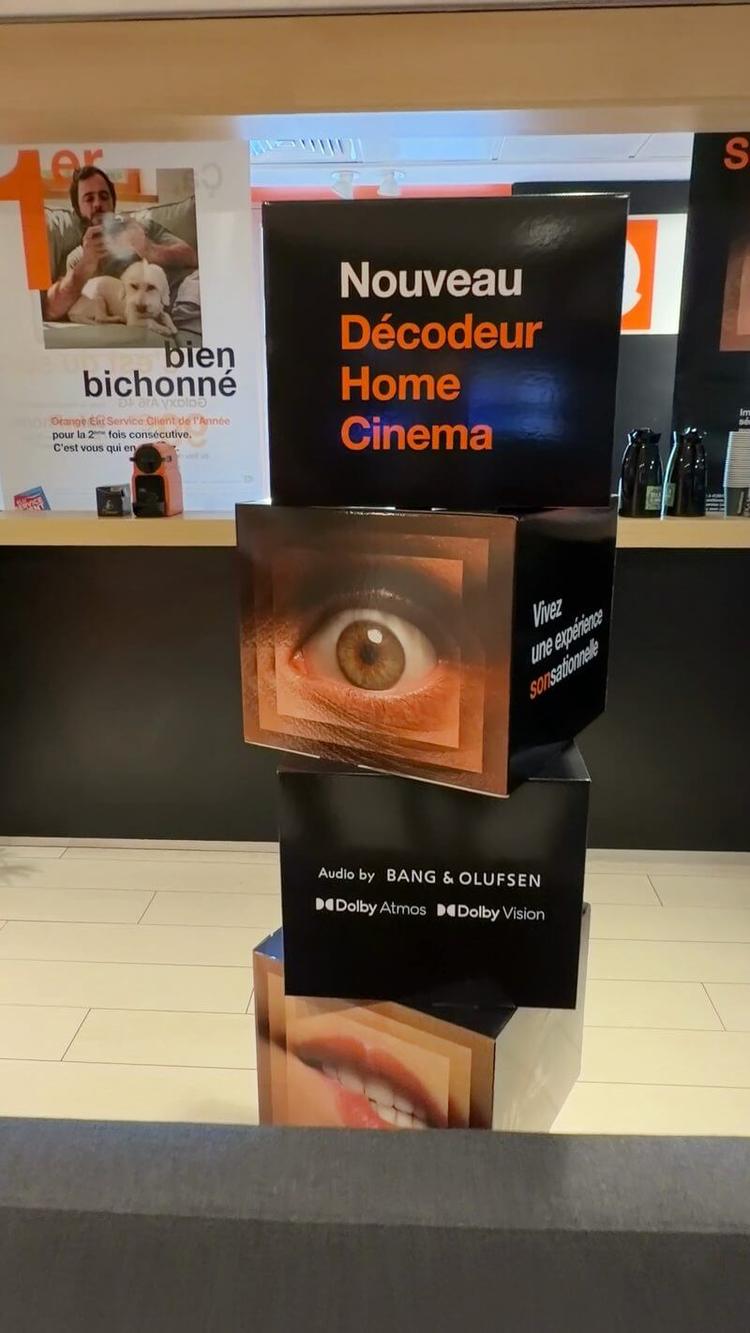 Détail du totem Orange avec les logos Bang & Olufsen, Dolby Atmos et Dolby Vision