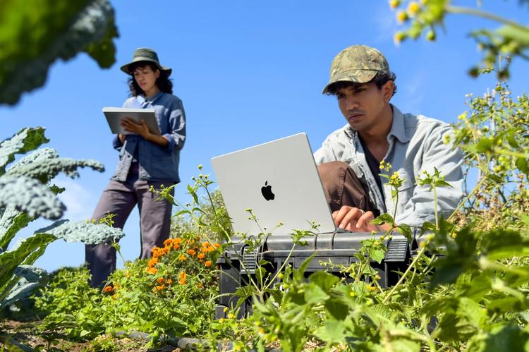 Two people in nature using the silver Macbook Pro