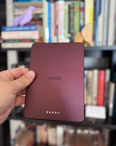 back of kindle colorsoft held in front of a bookshelf