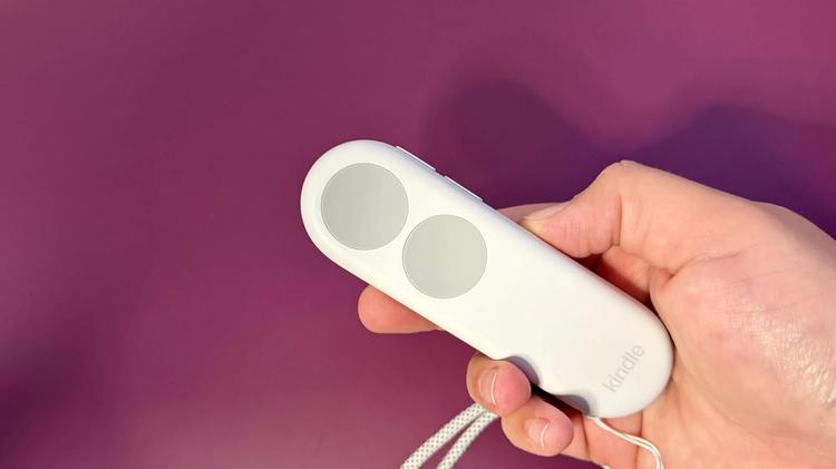 A hand holding a Kindle Click