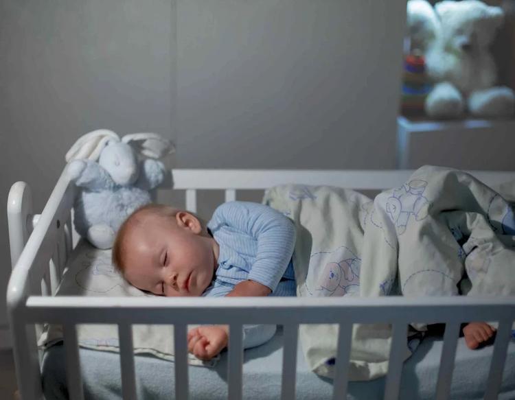 Baby sleeping peacefully in a cozy, dimly lit nursery with a calm and comfortable nighttime atmosphere.