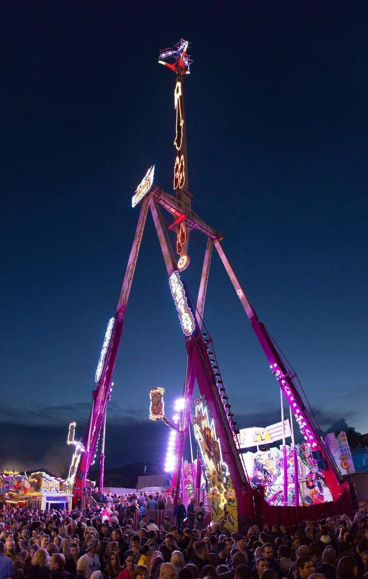 Le manège Infinity Inversion illuminé de nuit au-dessus de la foule