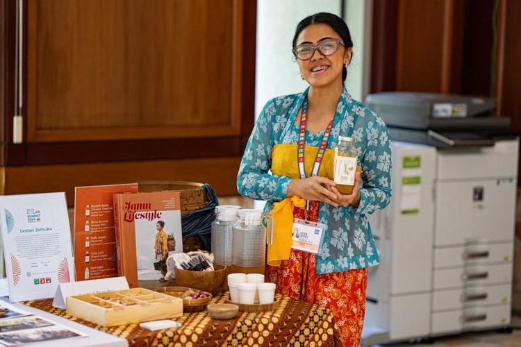 Intan Rahmaningtyas com garrafas de jamu, bebida com efeitos medicinais: receitas resgatadas para unir tradição e futuro na Indonésia (Foto: Lestari Jamuku / Divulgação)