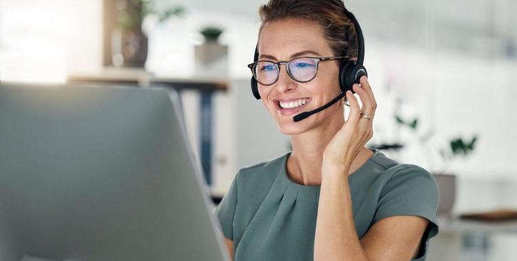  Frau sitzt mit Headset am Laptop - Beratungs-Hotline