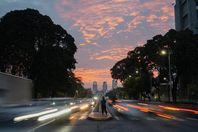 Una mujer observa el atardecer en la avenida Bolívar.
