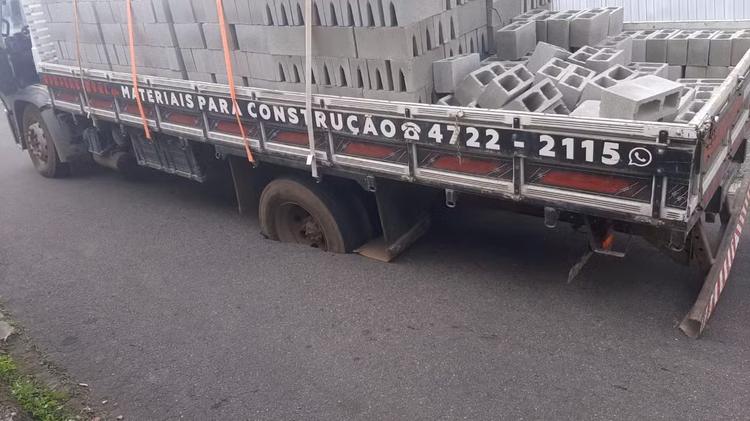 Caminhão fica preso em buraco em rua de Mogi das Cruzes