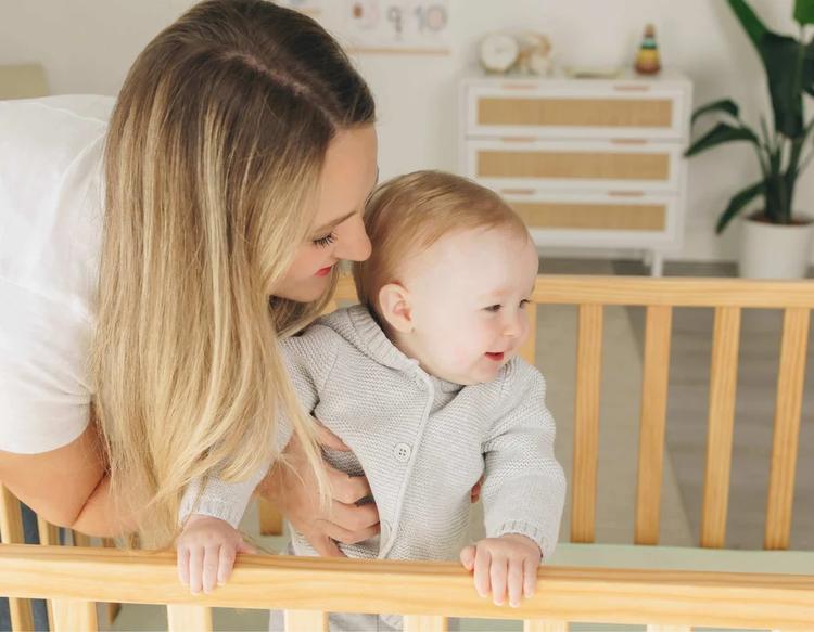 Mother preparing her baby for a daytime nap in a cozy nursery with KeaBabies baby essentials.