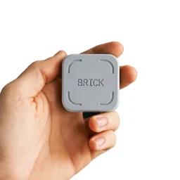 hand holding gray brick device