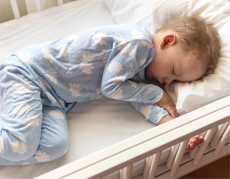 Top view of a 2- to 3-year-old preschool boy sleeping peacefully in bed.